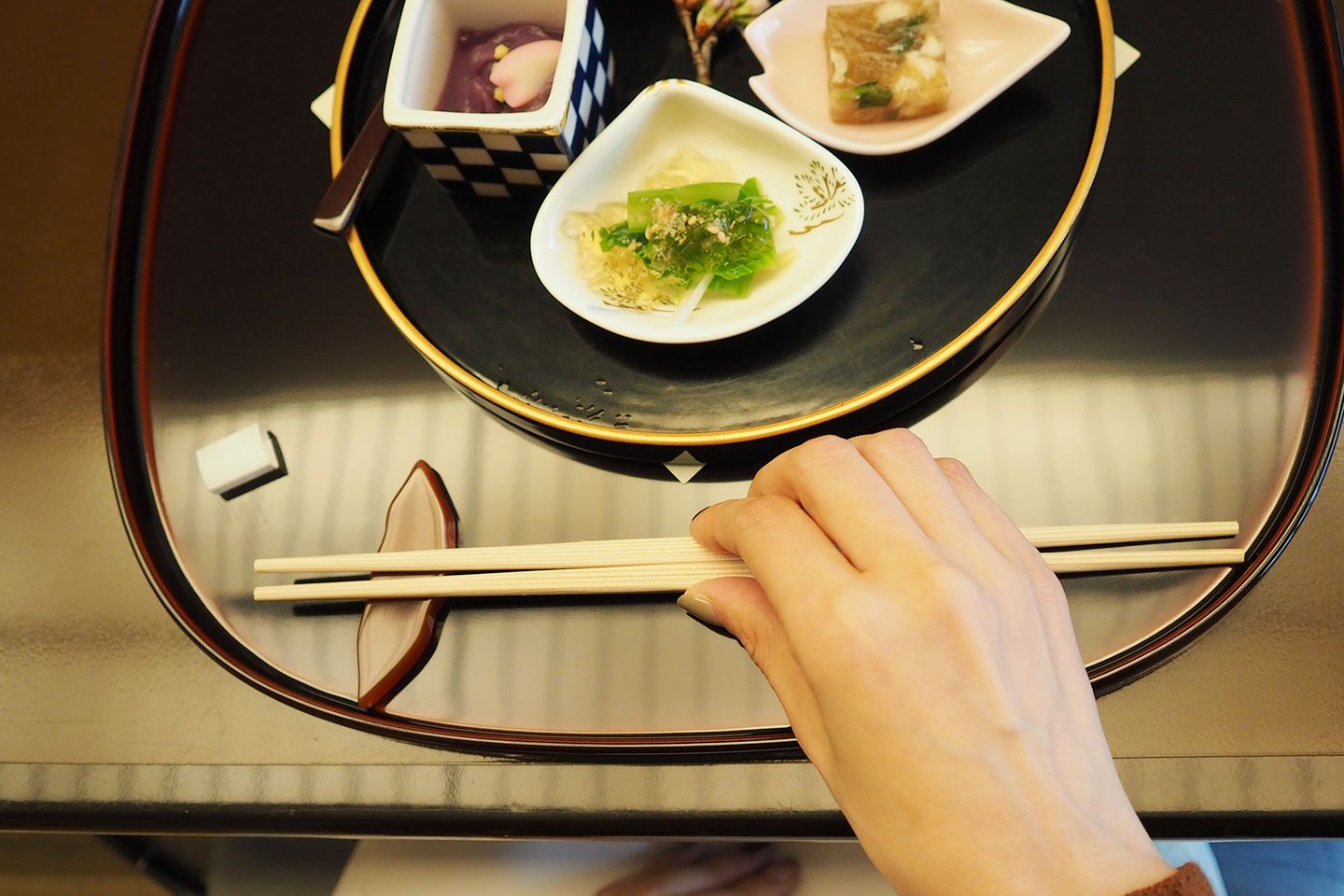 右手で箸置きにあるお箸の真ん中あたりを上から持ち、持ち上げます。
