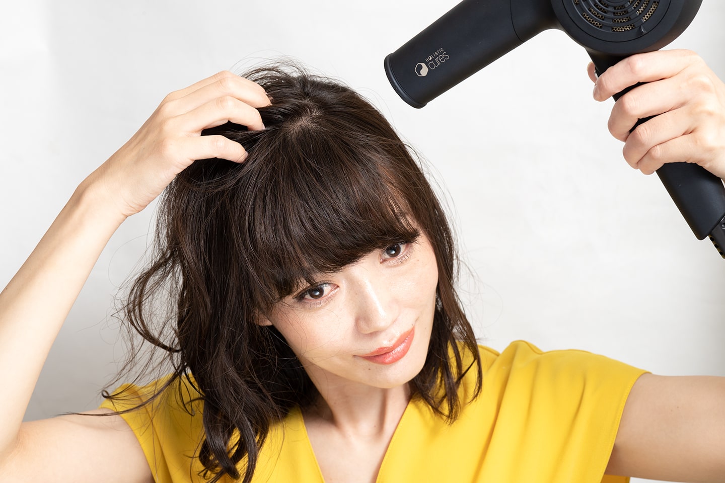 サイドも後頭部も髪を中央に集めるように手ぐしでとかしながらドライヤーをあてる。