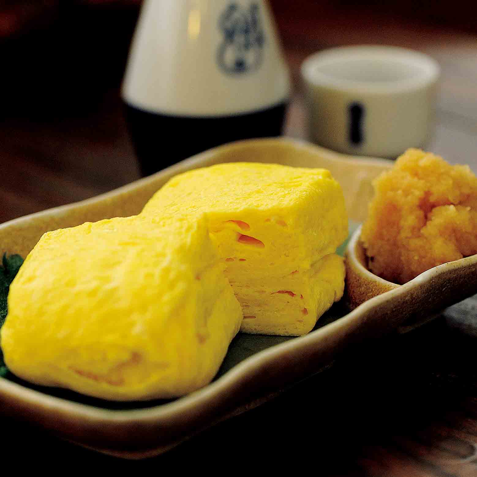 卵3個を使ってふっくら焼き上げた、名物玉子焼き¥800。だしのきいた甘くない味が男性に好評。日本酒(菊正宗)¥600。