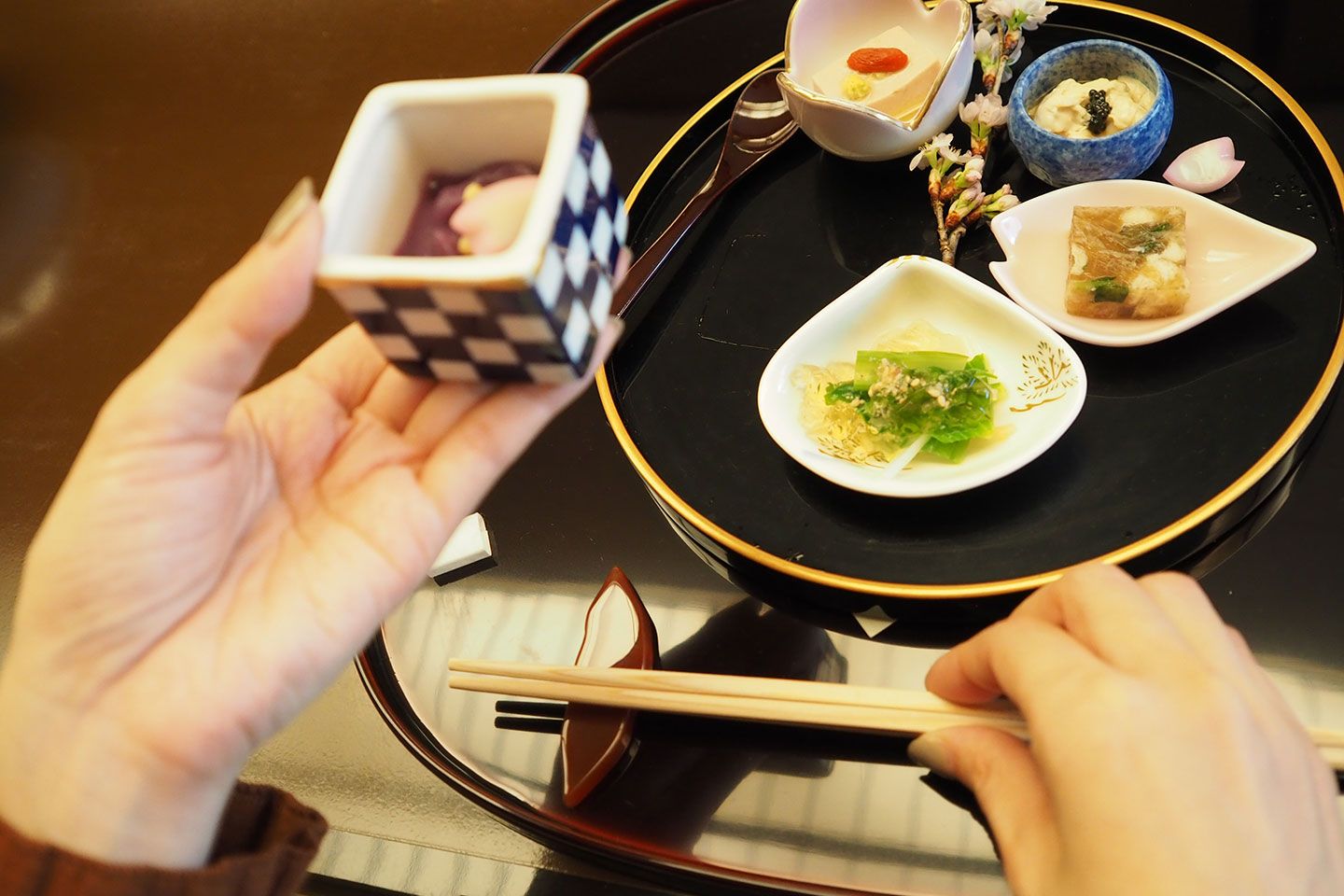 器を左手で持ち、右手で箸の真ん中あたりを上から持って、持ち上げます。