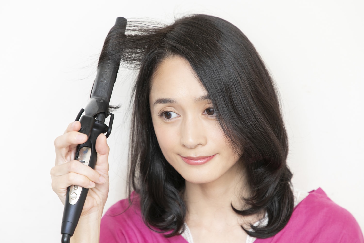 外しておいたトップの髪を、中間から内向きに1.5回転巻く。全体を巻き終わったら指で崩す。