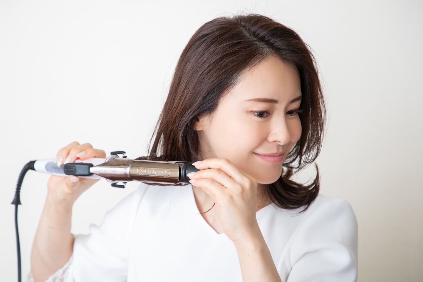 コテは28mmを使用。両サイドの毛束を取って毛先だけ外ハネにする。