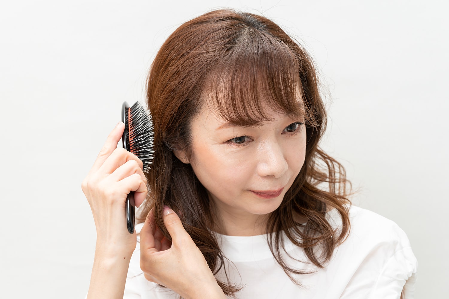 巻いた髪をほぐすようにブラシでとかす