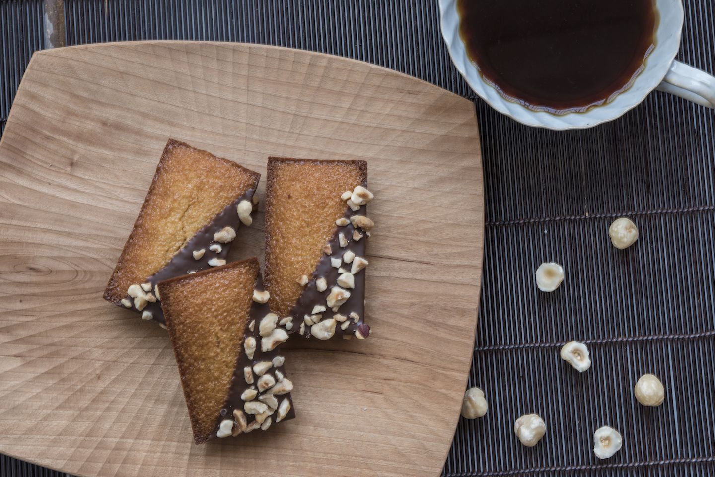 ミルクチョコレートの上にコーティングされたヘーゼルナッツの、サクサクッとした食感と香ばしい風味は、コーヒーとの相性も抜群! 焼きフィナンシェ「ヘーゼルナッツ」¥180(税抜)