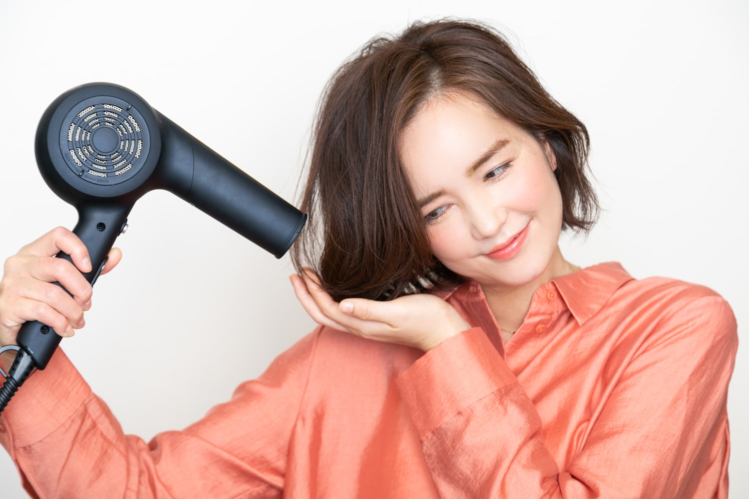 毛先を手のひらにまとめて、持ち上げるようにしながら乾かして、パーマを出す。