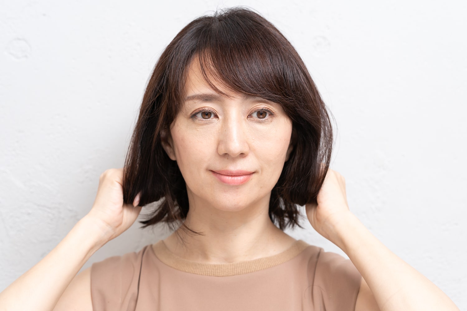 襟足など肩のラインにかかる髪の毛先が外はねになるよう、手ぐしで整える。