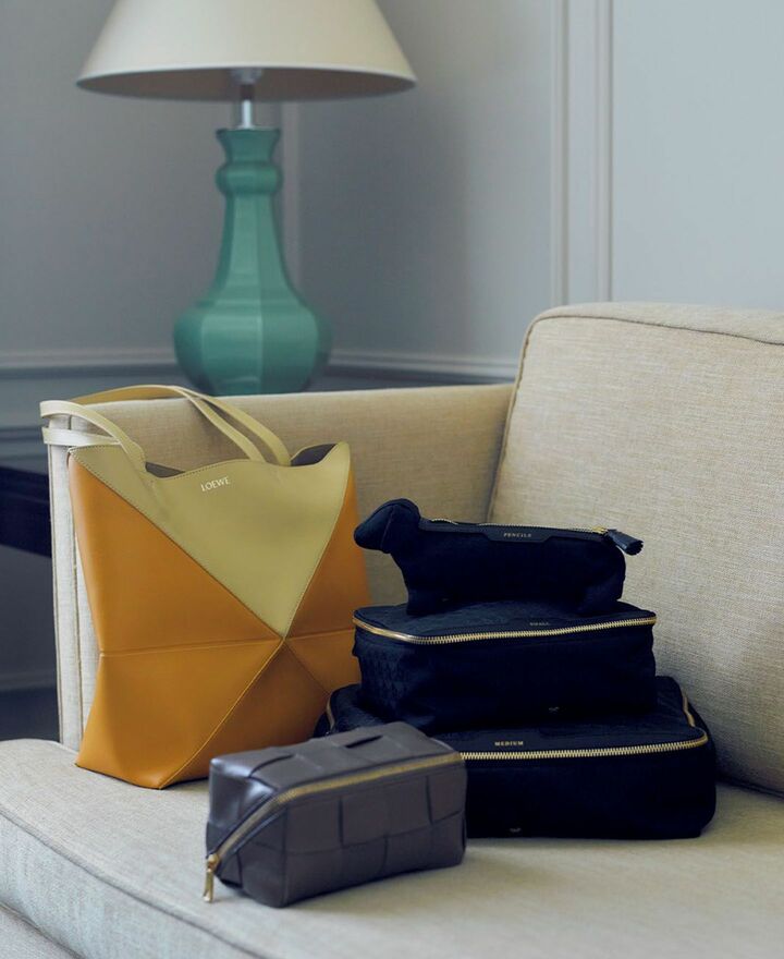 ペンシルケース［縦10×横25×マチ5cm］￥31,900・パッキングケースS［縦18×横23×マチ9cm］￥35,200・M［縦26×横33×マチ9cm］￥38,500（アニヤ・ハインドマーチ ジャパン）、バッグ『パズル トート』［縦31.5×横25.5×マチ14.5cm］￥266,200（ロエベ ジャパン）、ビューティケース［縦9×横18×マチ9cm］￥236,500（ボッテガ・ヴェネタ ジャパン）