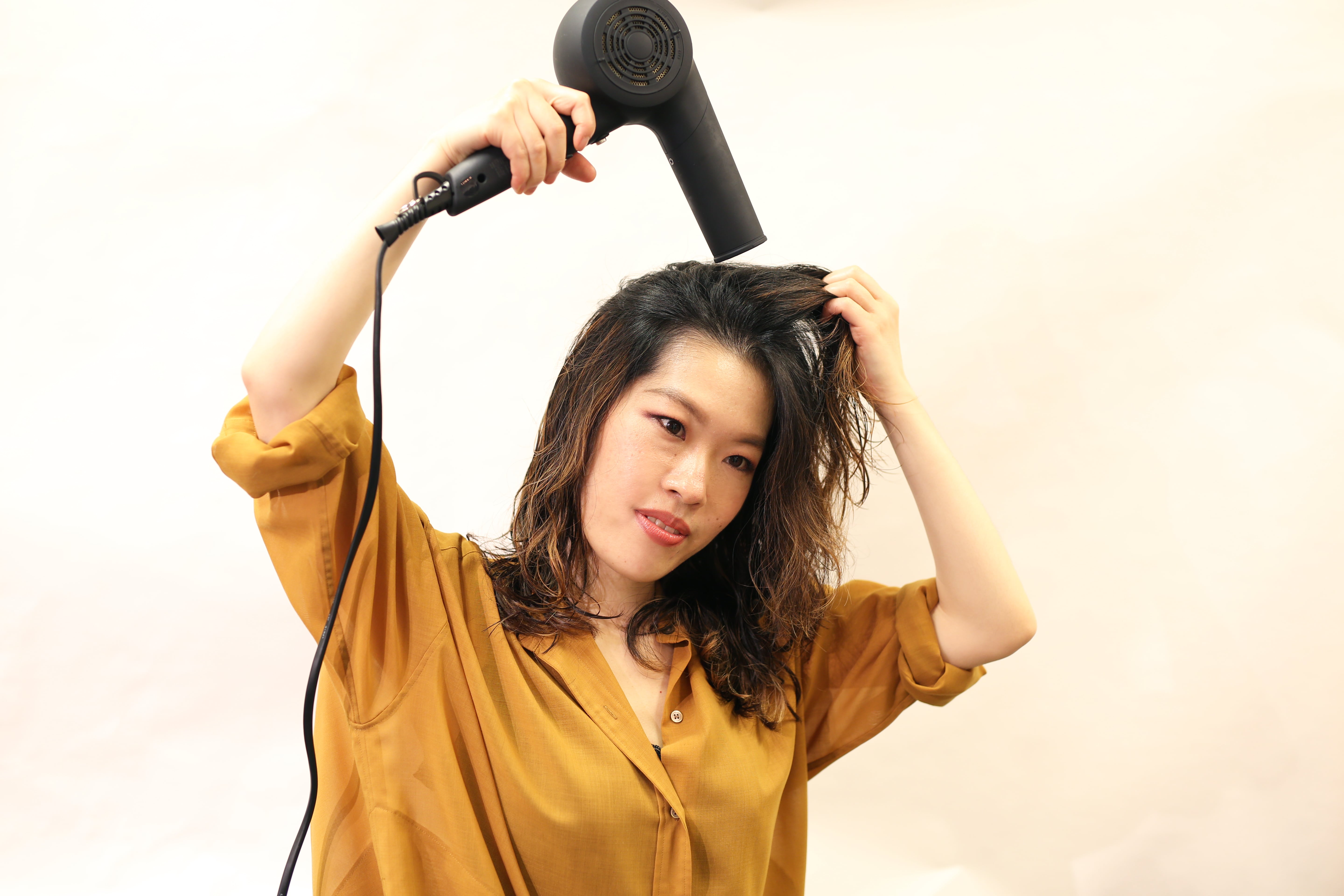 頭を下に傾けながら、根元を立たせるように乾かす。ドライのプロセスで一番重要。