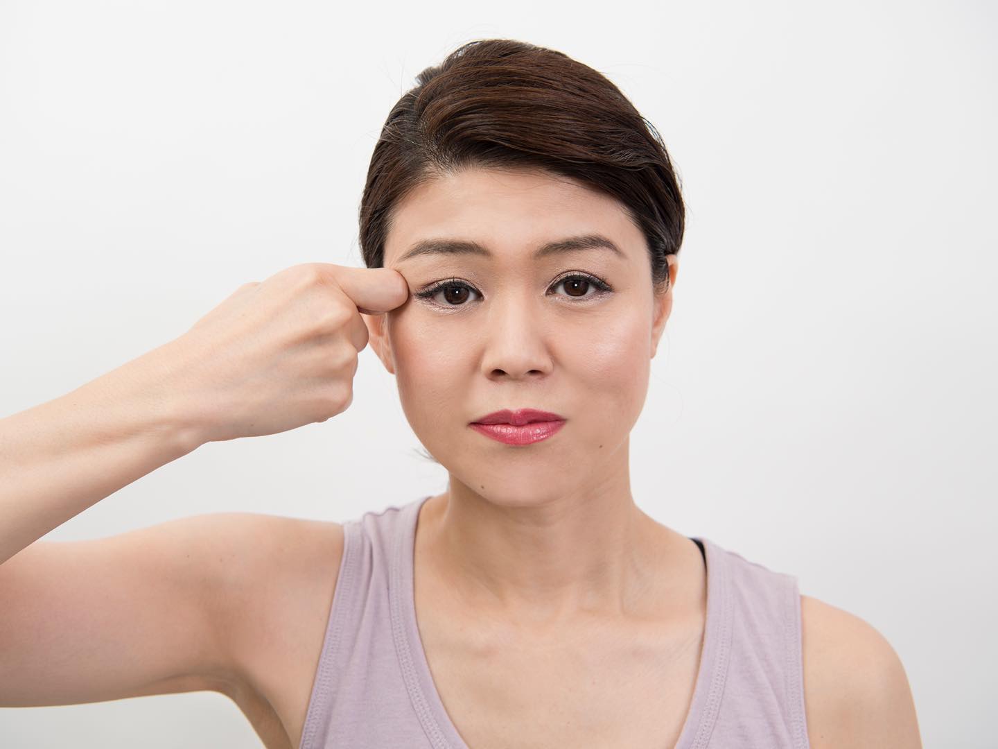 目尻を指圧している女性
