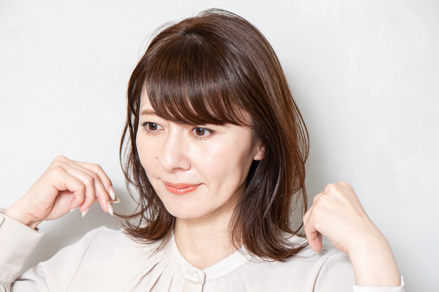 小指の爪くらいのシアバターを取り、中間、毛先、前髪の順につまんでなじませる。菱形シルエットに整えて完成。