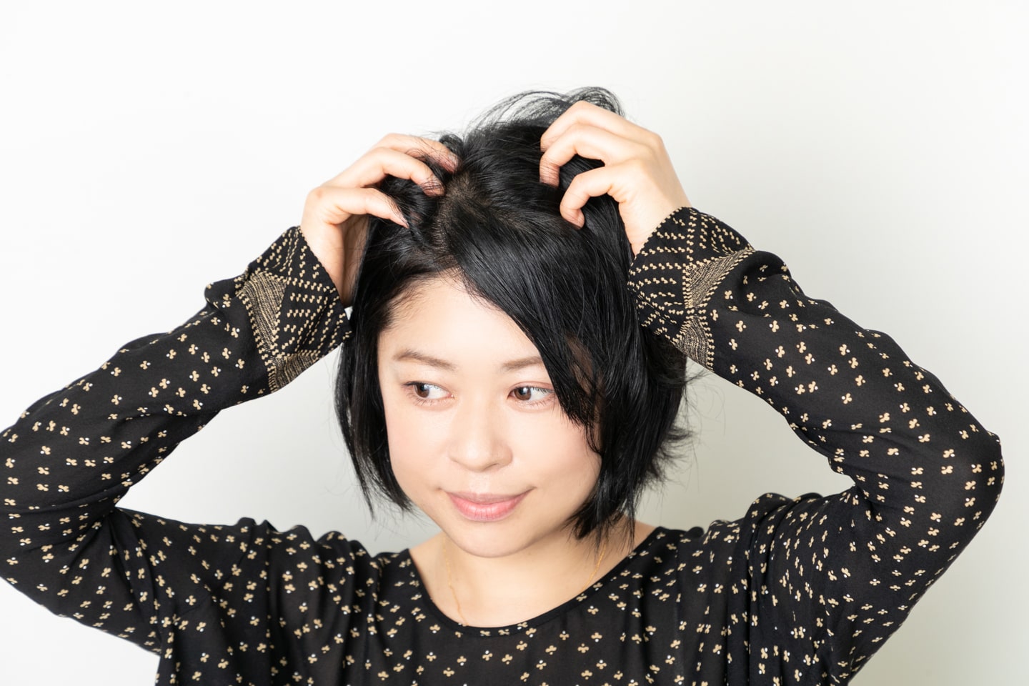 両手のひらにバームやワックスをなじませたら、髪に空気を含ませるようにしてなじませる。