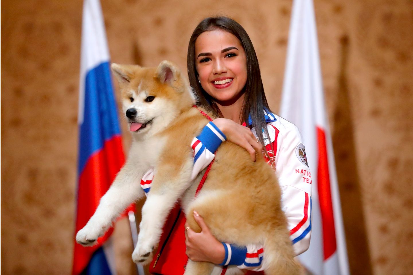 秋田犬の贈呈式にて。笑顔でマサルを抱っこするザギトワ選手。