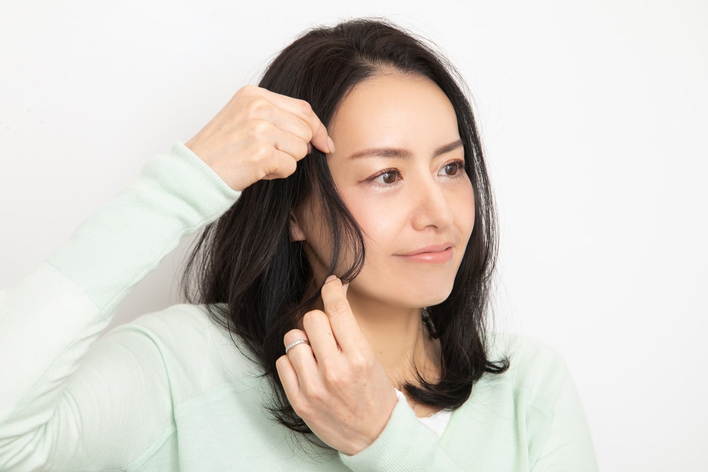 前髪は、目尻~頬骨を通るイメージで、毛束をつまんでスタイリング。