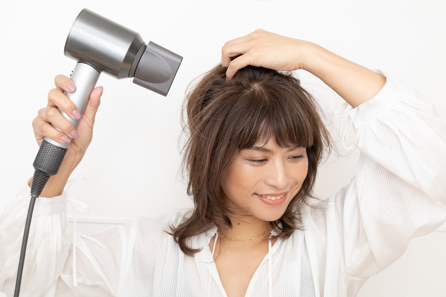 髪の根元にドライヤーの風が当たるように乾かす。