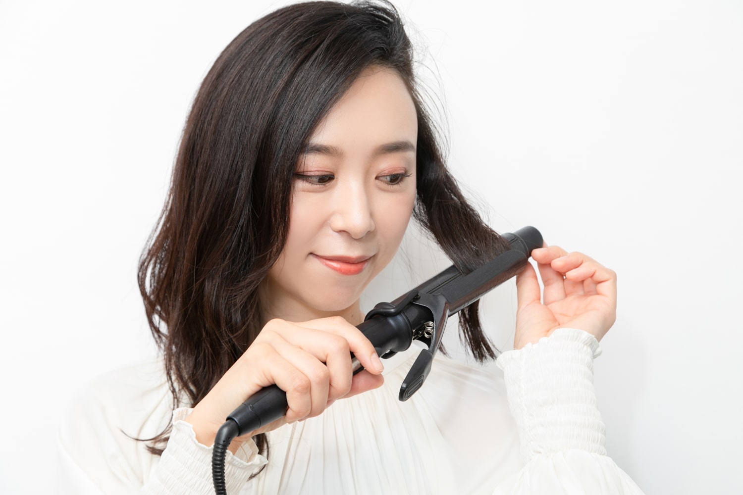 1で巻いた1段上に、内巻きでヘアアイロンを当ててクセをつけ、S字を作る。