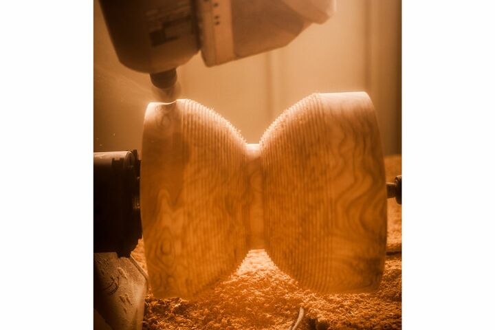 コンピュータで制御して切削を行うNC加工機を駆使し、無垢の巨大な木材から複雑な曲線を正確に削り出す。
