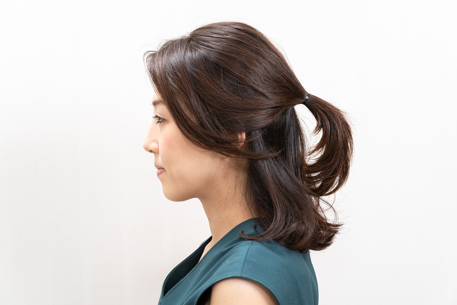 両耳の先端を結んだ位置に結び目がくるように束ねる。