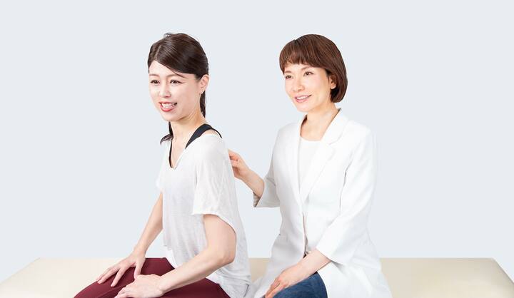 並んでいる二人の女性 ストレッチの指導をしている