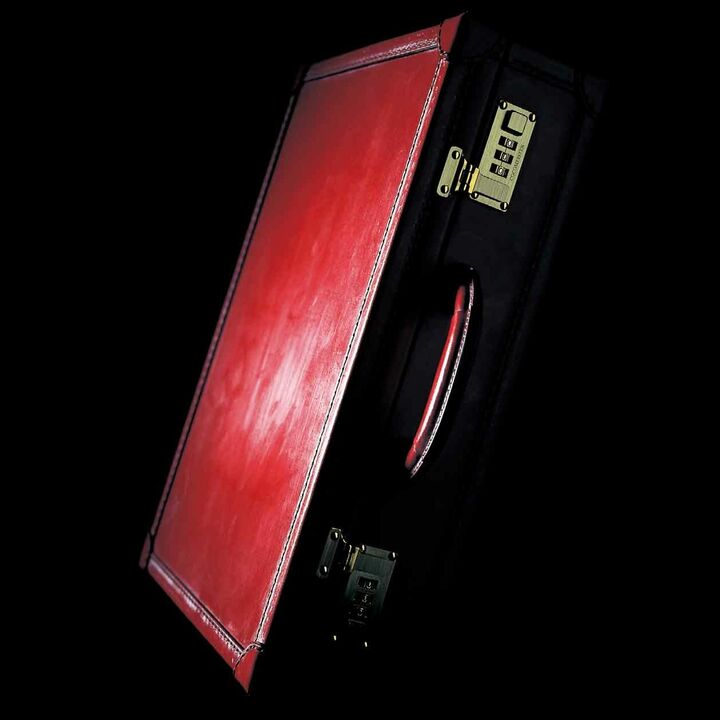 ブライドルレザー製のビジネスバッグには、スイス「amiet社」にオーダーした真鍮製の錠前等、クラシカルなディテールが重厚感を演出。写真のスイスレッドのほか全７色展開。※ブライドルレザーの味とも言うべき表面に出てきているロウが溶けるまでは、馬毛ブラシで適度なブラッシングがおすすめ。［縦32.8×横43.9×マチ11.8㎝］¥333,333（ココマイスターオンラインサポート）