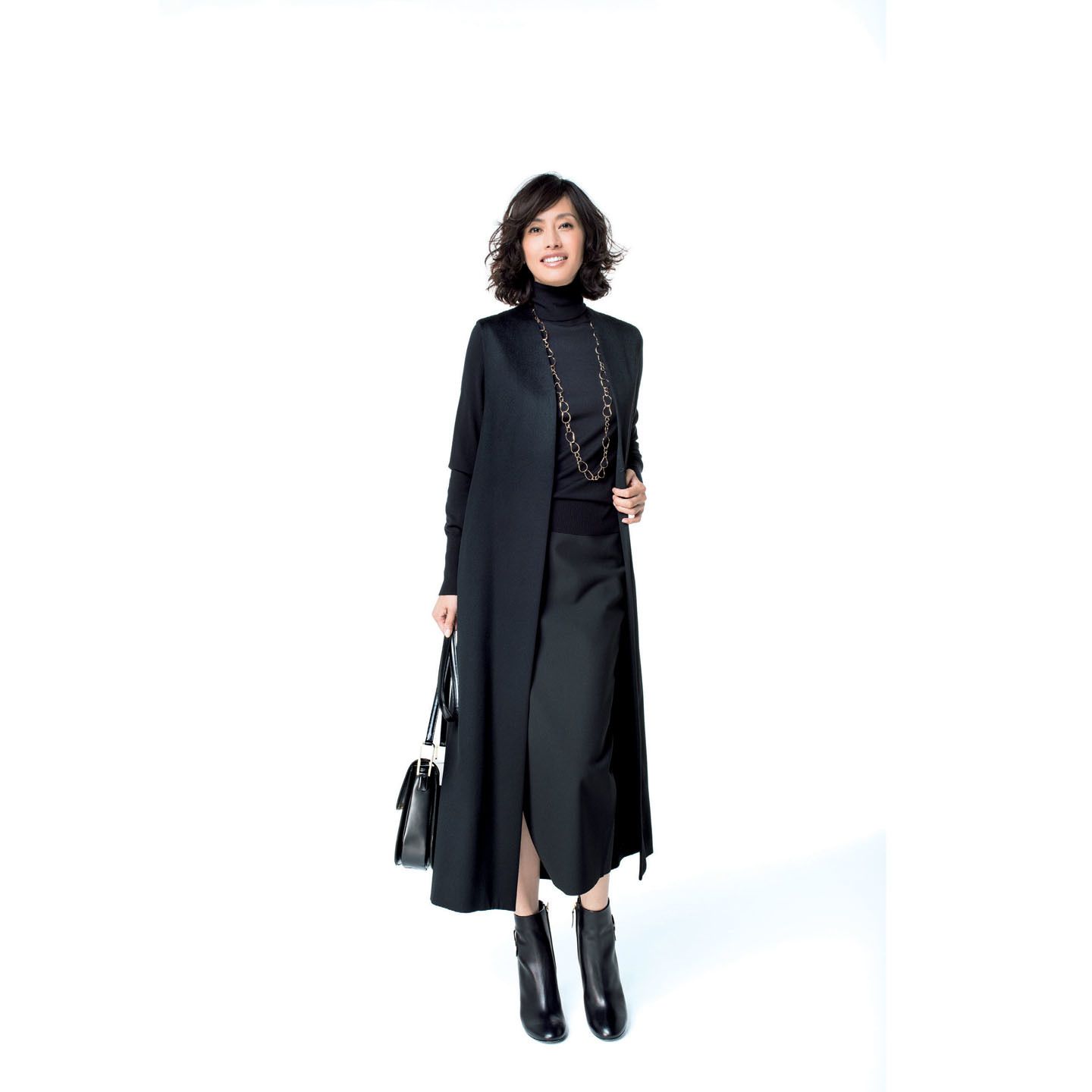 ウールのロングジレ(Nobuko Nishida)、ニット(ADORE)、スカート(コロネット〈エリザベス アンド ジェームス〉)、ネックレス(シャンテクレール 東京店)、バッグ(yoshie inaba)、靴(ロジェ・ヴィヴィエ・ジャパン)