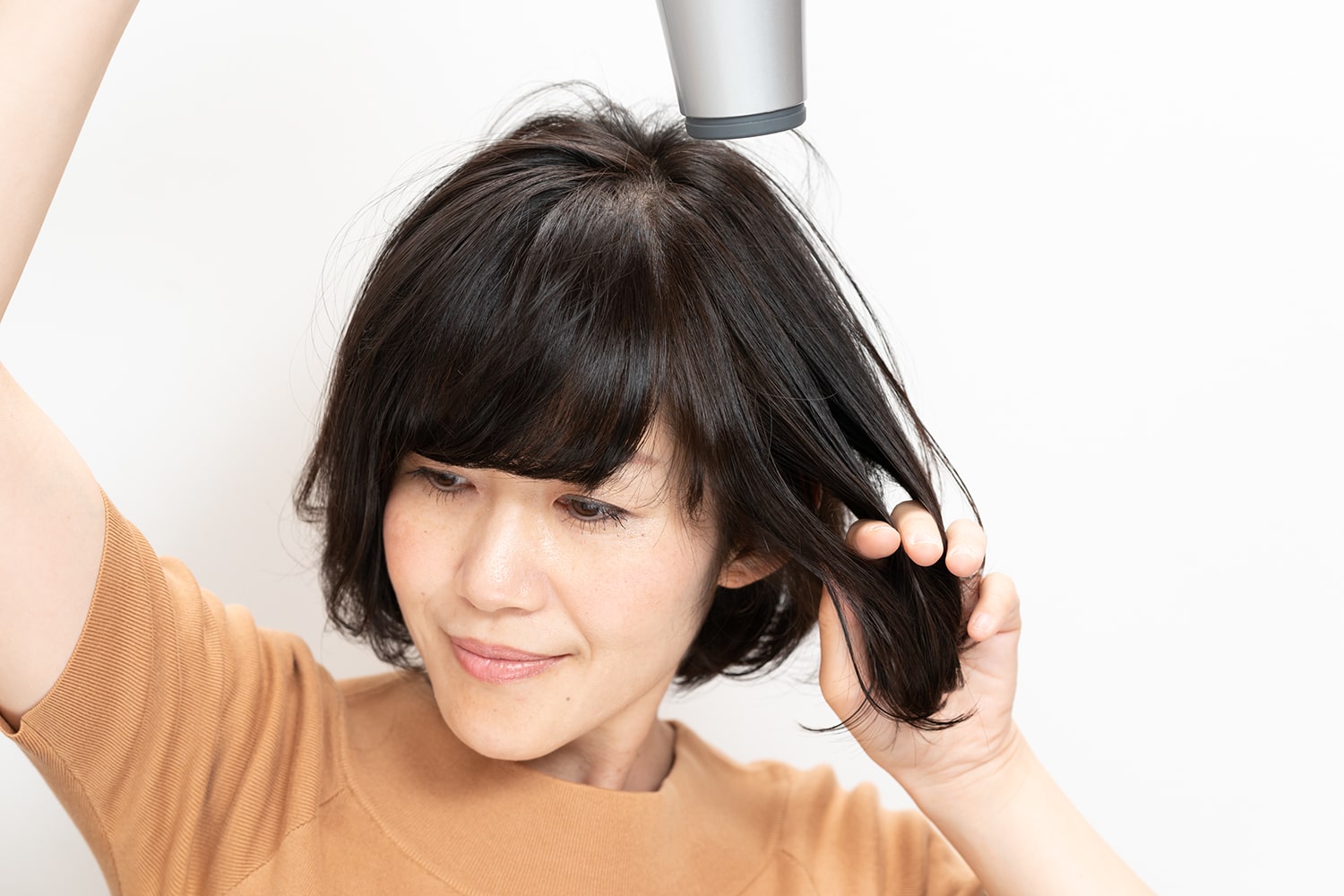 髪の内側から手を入れ、軽く引っ張るようにしながらとかすのがポイント。