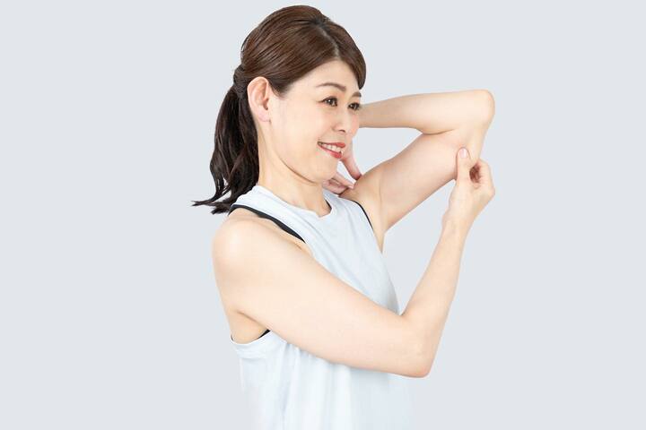 親指と人さし指ではさむように上腕三頭筋をほぐす