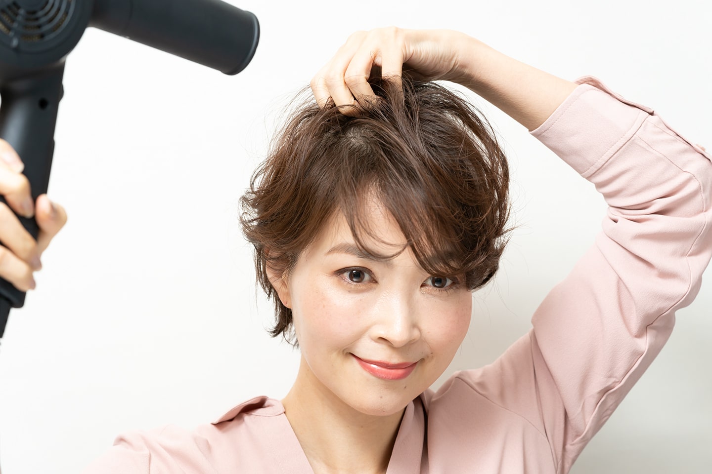 ボリュームが欲しいトップの毛束の根元にドライヤーをあてる。
