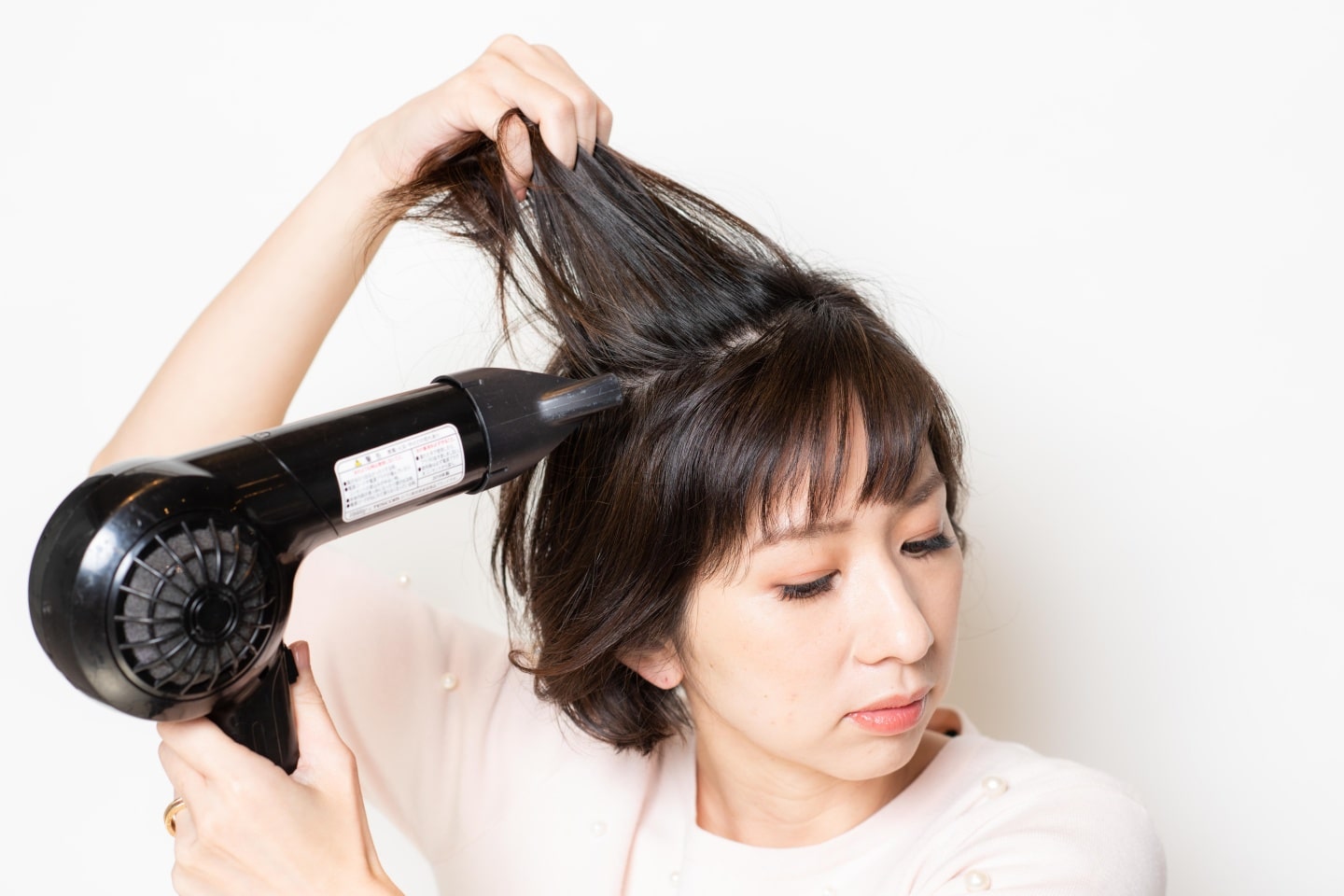 ドライヤーの風を根元に当て、分け目をつけずに根元を立ち上げながらしっかり乾かす。