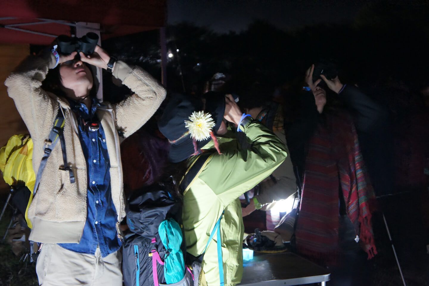 天体観測イベントにて、双眼鏡を手に思い思いに星空を眺める女性たち