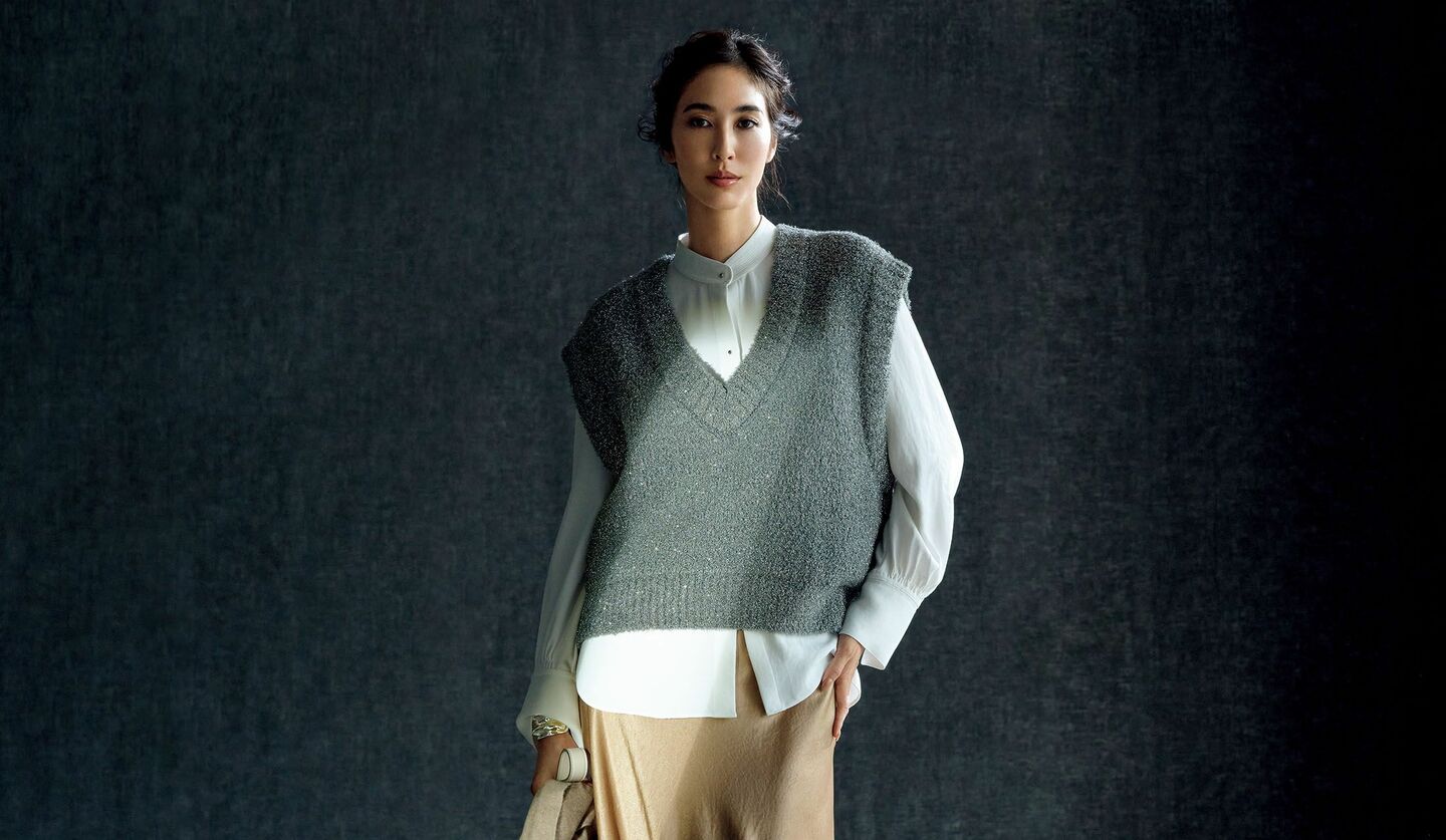 「ヴィンス」の白シャツ、「オーヴィル」のラメニット、「リヴィアナ コンティ」のサテンスカートを着用したモデル