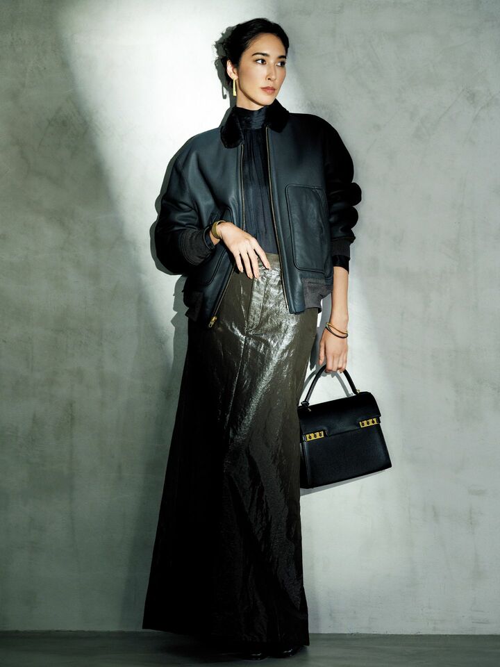 ムートンレザーのブルゾンにシャイニーツイルのマキシスカートを合わせたモデルの立野リカさん