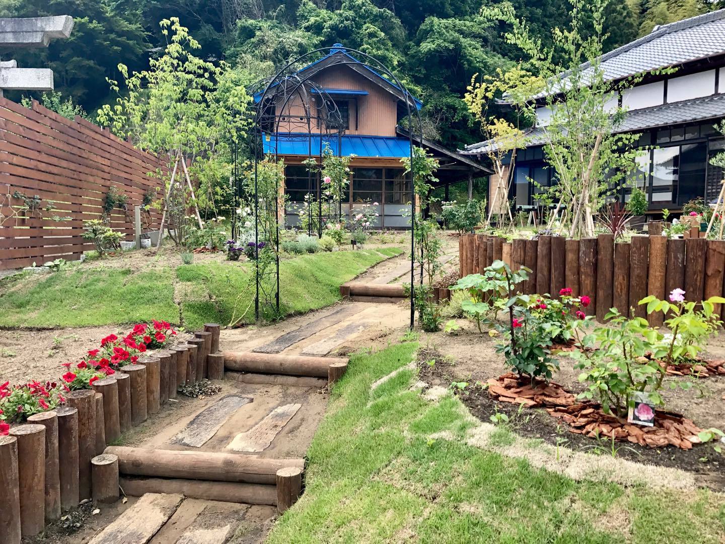 家の入り口から見た全景。お客さまの導線に花々を