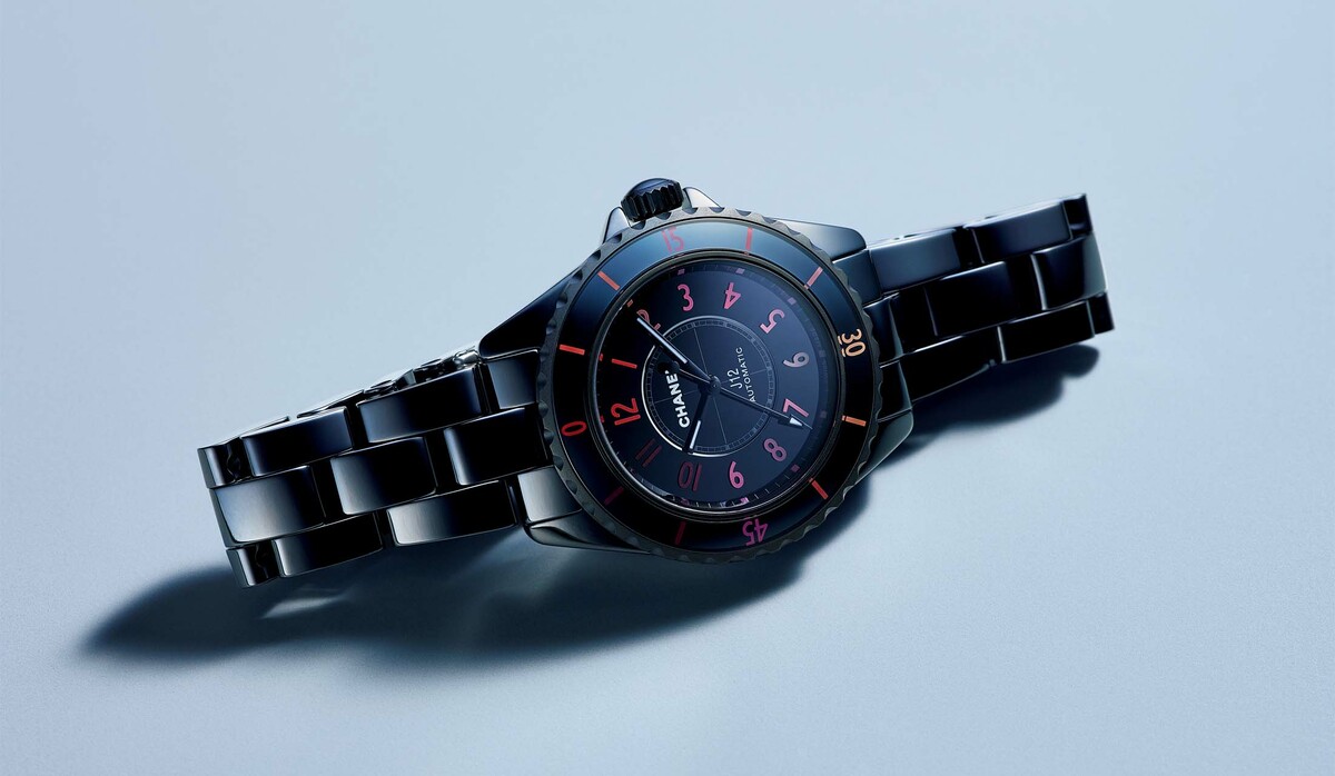 シャネル」ブラック セラミックににじむピンクとレッドの