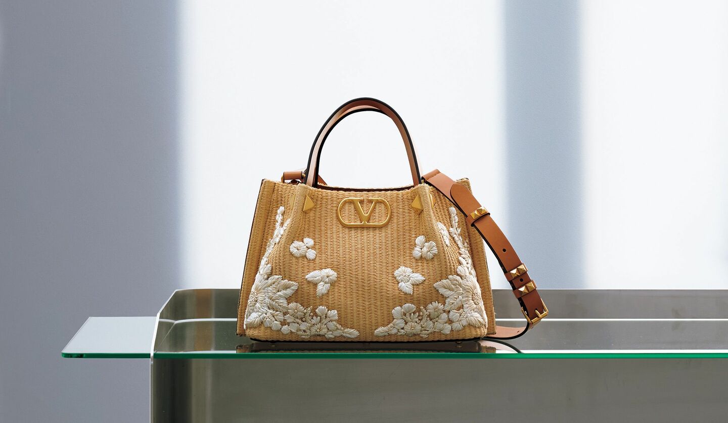 ナチュラルな風合いとなめらかさを備えたラフィア風素材に、メゾンが誇る丹念かつ高度なハンドワークで立体的なフラワー刺繍を配して。「ヴァレンティノ ガラヴァーニ」のバッグ『Vロゴ シグネチャー』