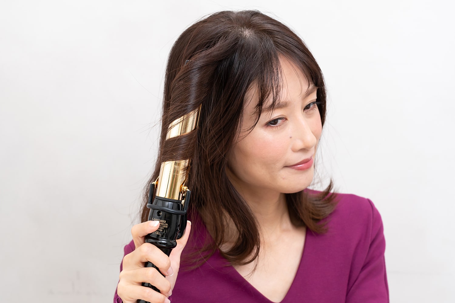 根元近くからカールアイロンに2回ほど巻き付けて。