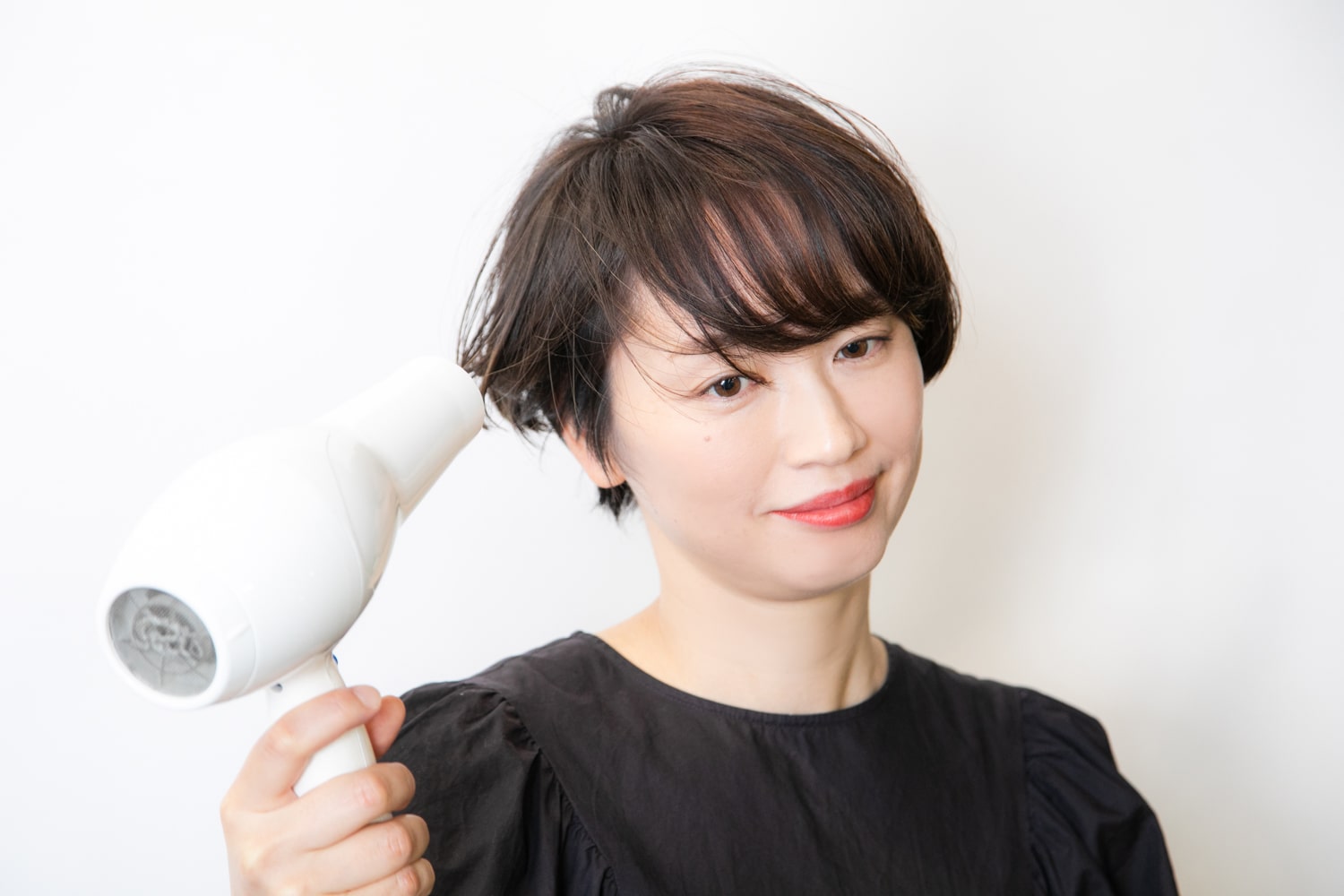顔周りからドライ。ドライヤーの風を下から当て、根元を起こすように後ろに向かって乾かす。