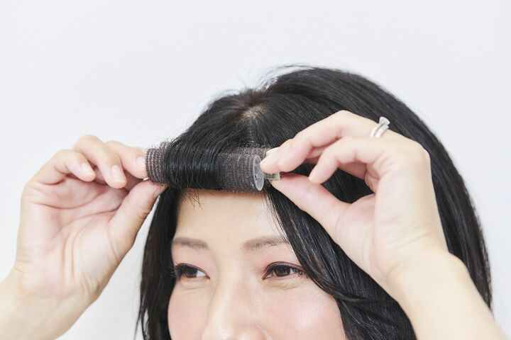 前髪にはクリップ付きのカーラーを使用。毛先をはさみ、根元までくるくる巻いて10分程おいておけば、自然な内巻きニュアンスに。