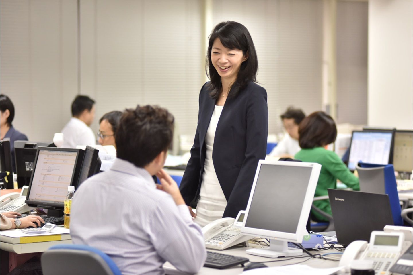 会社で社員と話をしている大西さん
