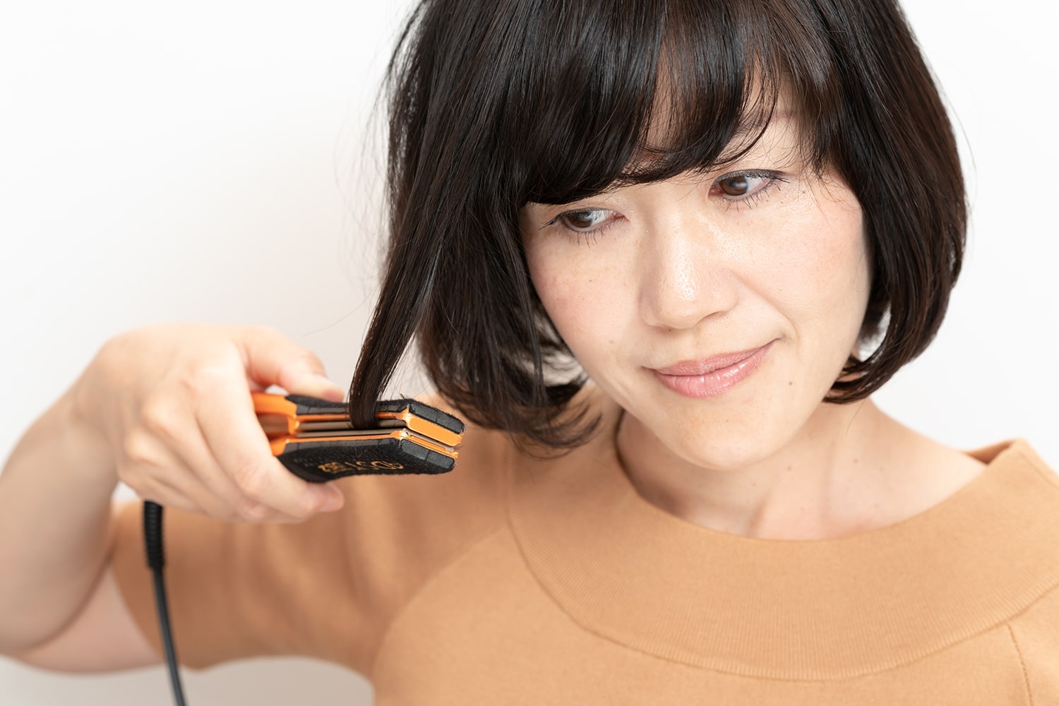 毛先付近まできたら、そのまま真っ直ぐ下ろさず内巻きに1カールさせる。