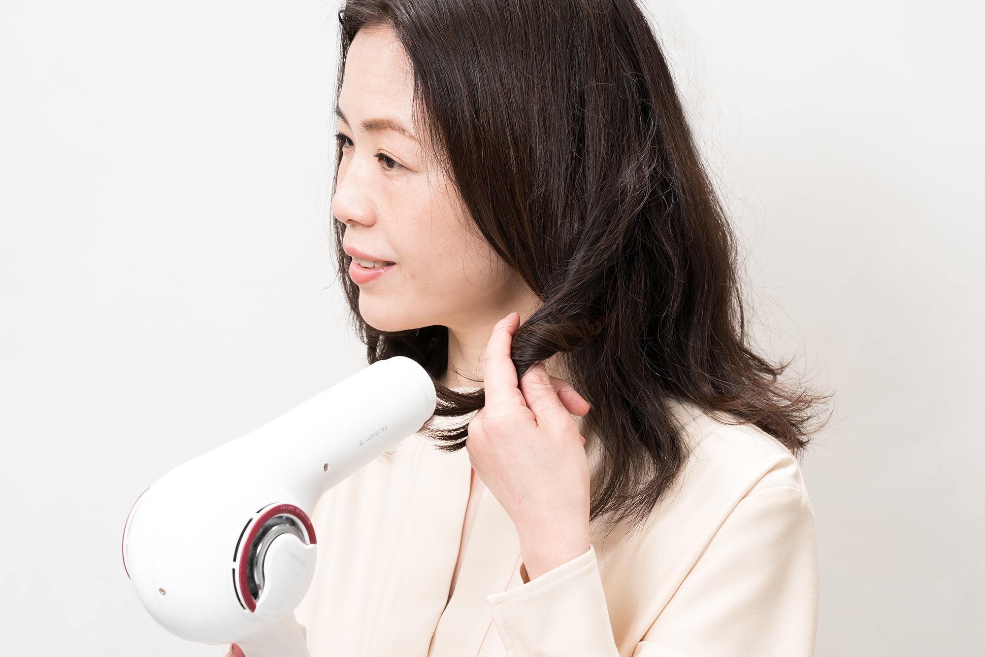指先で毛先をくるくるまとめながらドライヤー