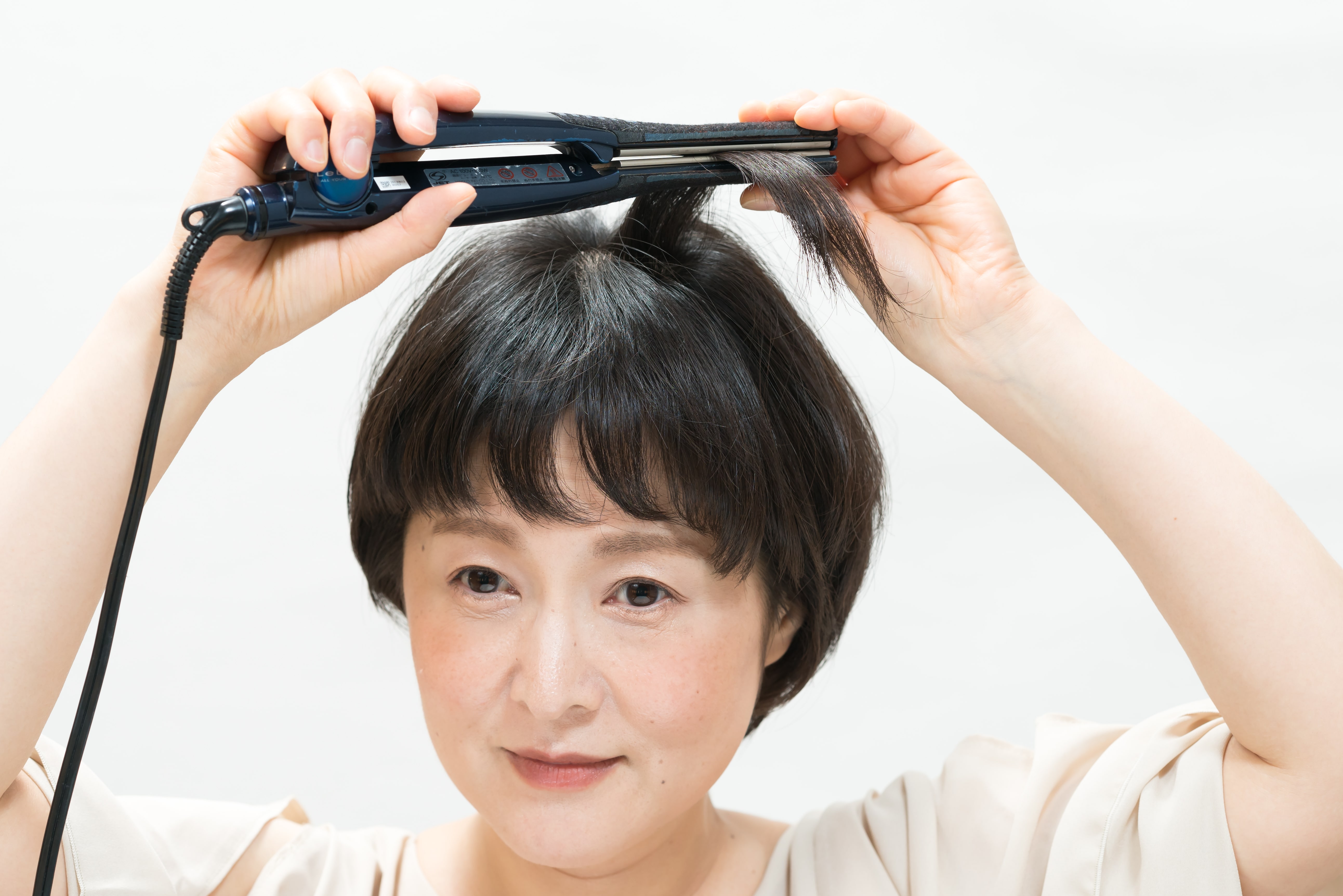 大きな円を描くように、毛束を内側に巻きます。頭頂部を中心にサイドからバックも同様に繰り返します。