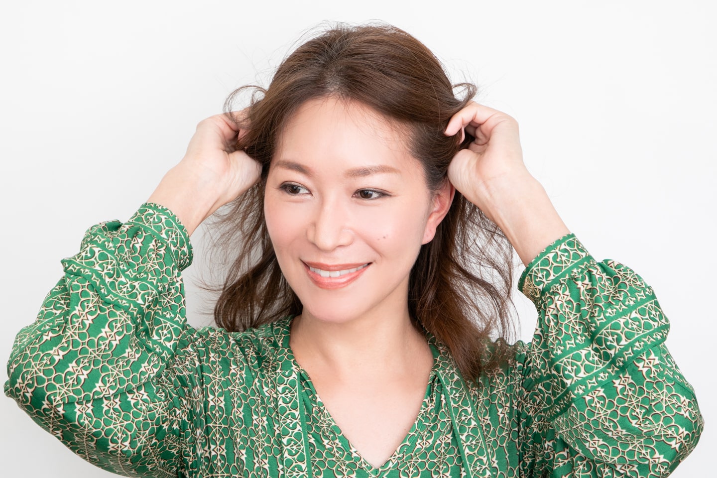 ピンポン球大くらいのムースを手に取ったら、こめかみの上にある毛束へなじませる。握るように揉み込むのがポイント。