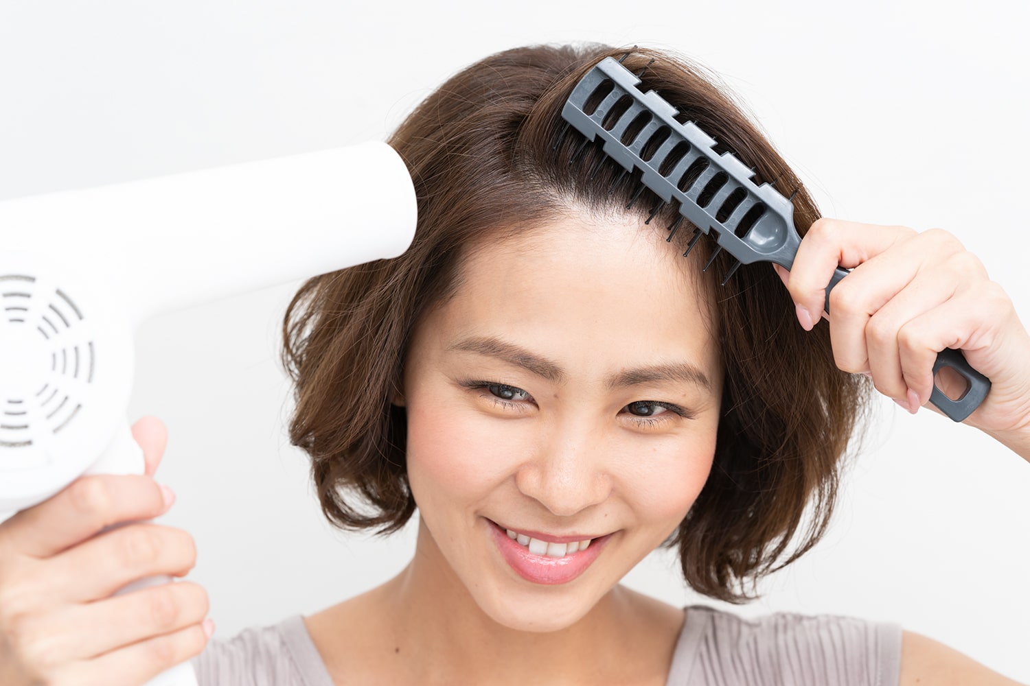 完成根元からブラシを入れて、かき上げるように動かしながら熱を当てる。