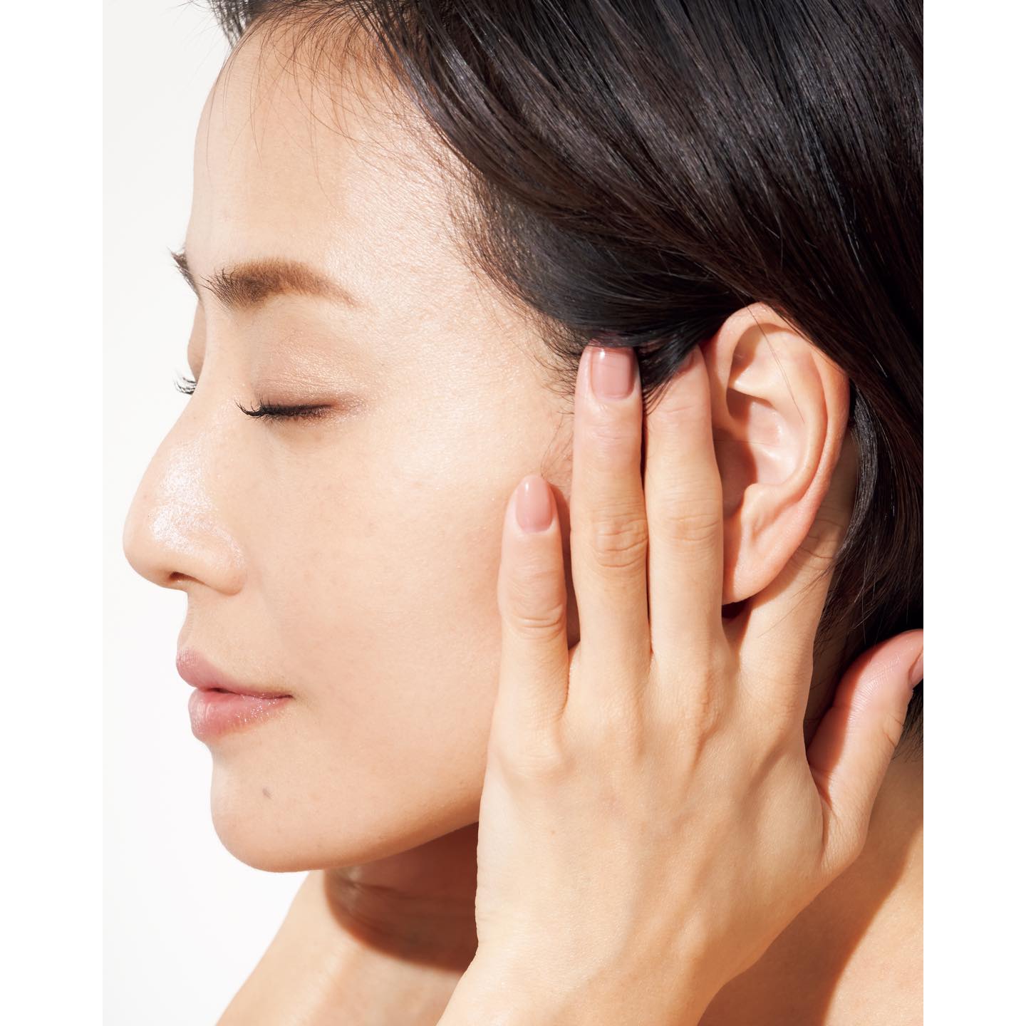 美容液を塗ったあと、イスに腰かけるか、立った姿勢で行う。人さし指と中指の間で耳を挟み、頭の重さを預けることで、圧をかける。