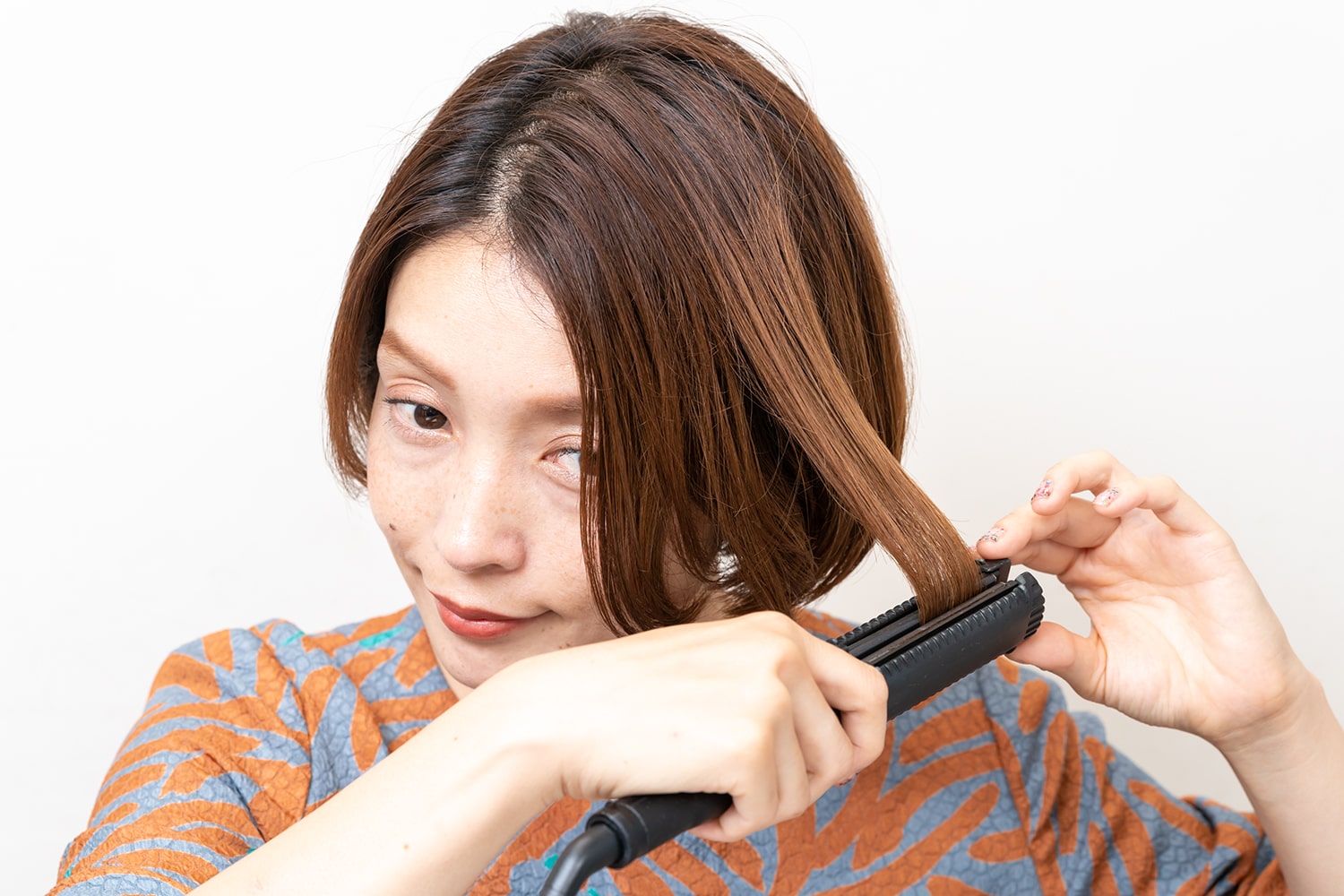 前髪、サイド、後頭部、全体にストレートアイロンで熱を通す。根元から毛先に向けてスルーさせるのがコツ。後頭部は表面の毛束だけでもOK。