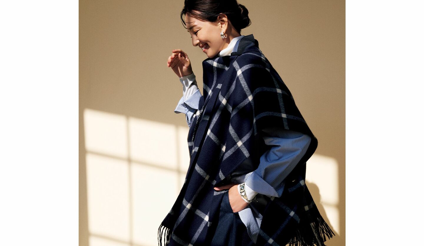 ネイビーのポンチョとシャツ、パンツを着用したモデル