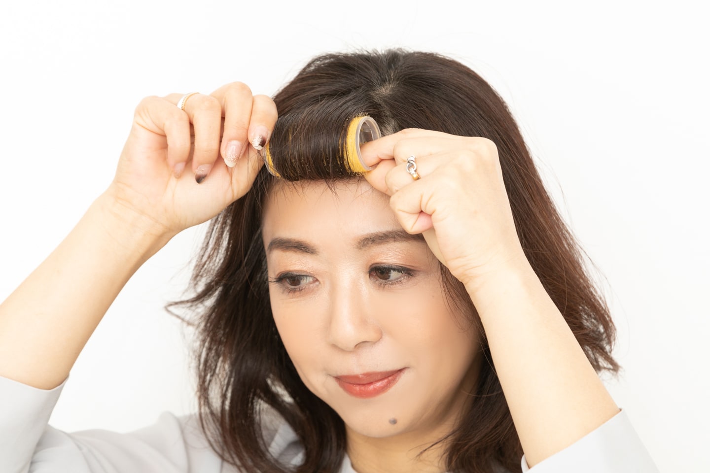 マジックカーラーで、前髪を毛先から根元まで巻き込む。