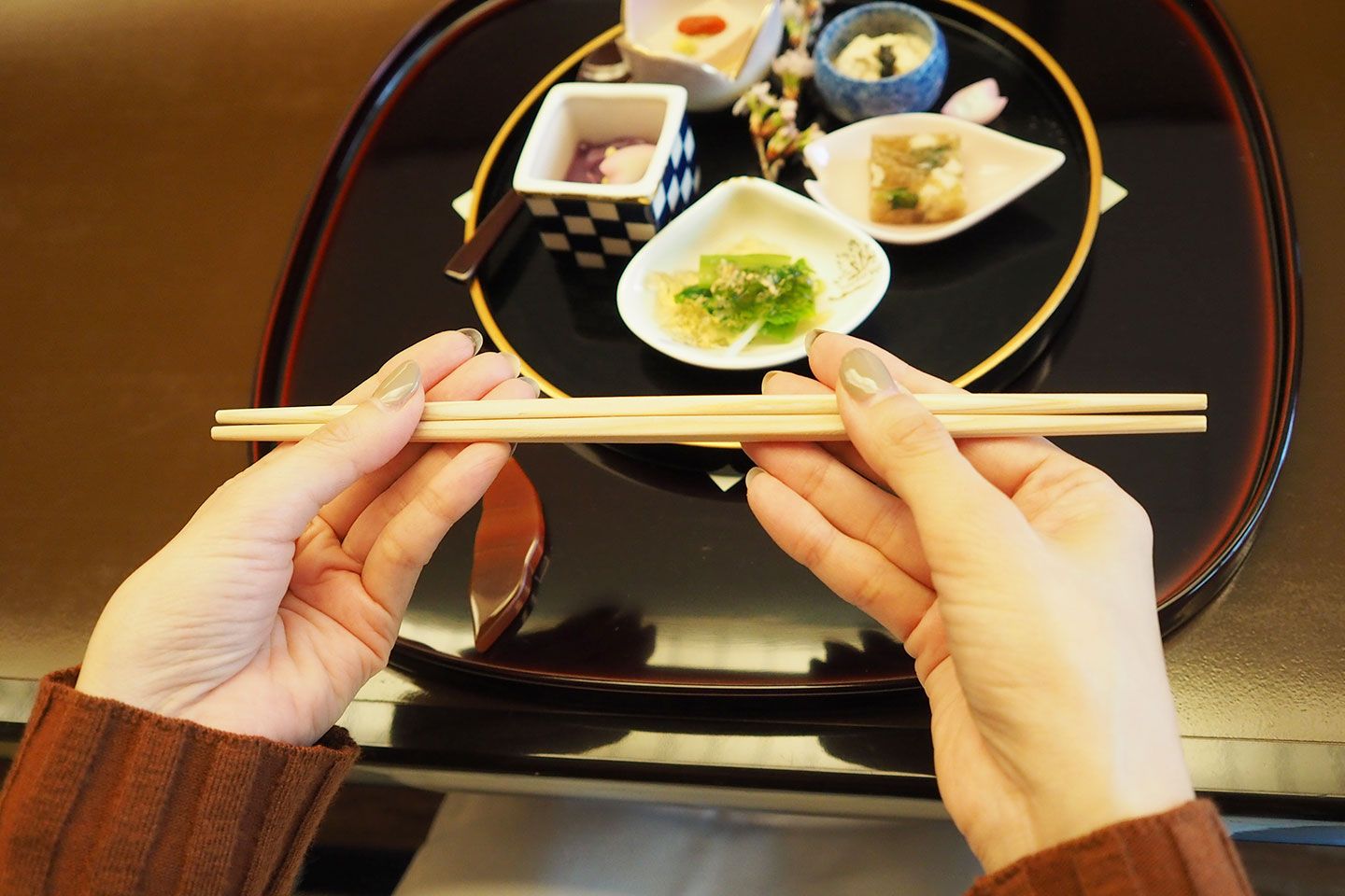 左手でお箸を持ったまま、右手を食べるときの持ち方に持ち替え、食事をいただきます ※写真より左手が中央寄りのほうがベターです