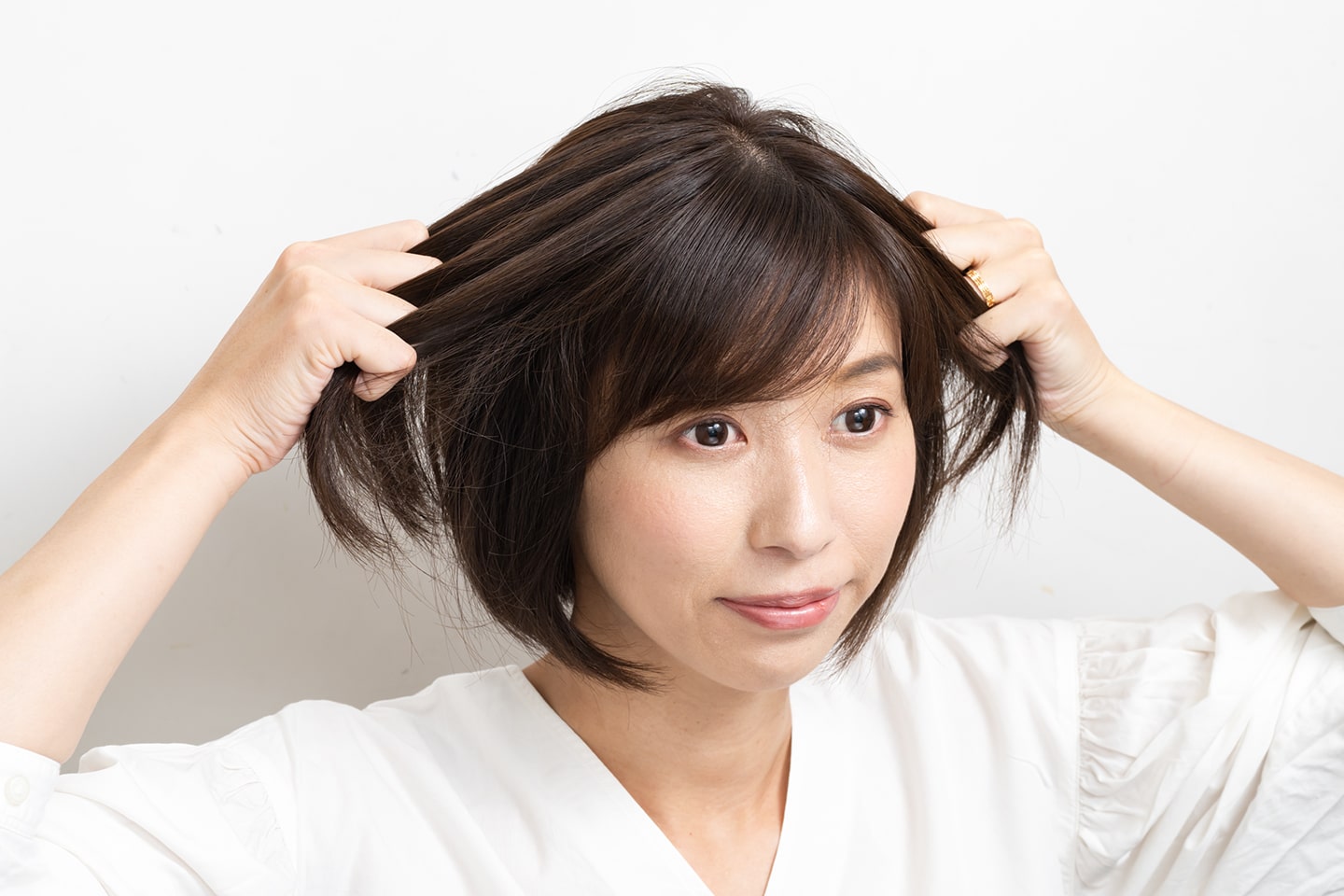 両手のひらにオイルを広げたら、髪を引っ張るように手ぐしでなじませる。