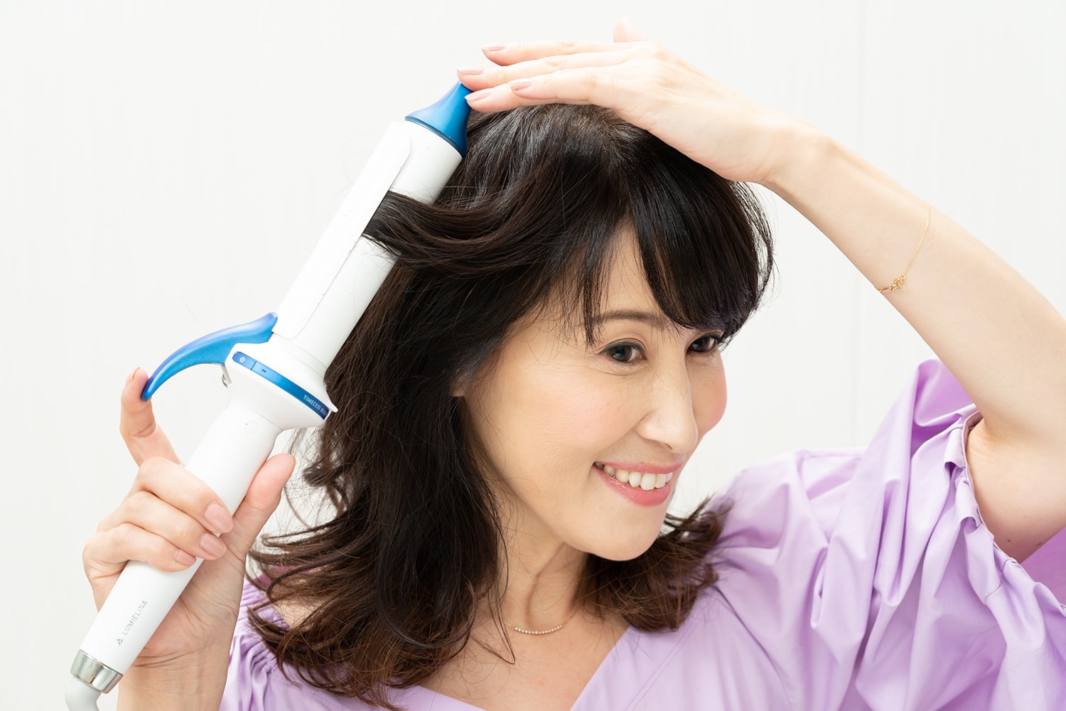 表面と顔周りの毛先をすべて外巻きに。1回転半を目安に巻きつけて。